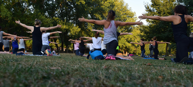 grupa ljudi u parku koji znaju da se pomoću joge može smršati