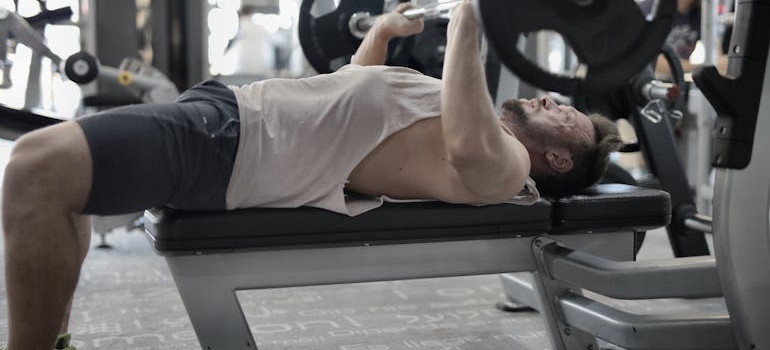 Osoba radi bench press.