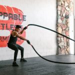 Muškarac vežba battle rope.