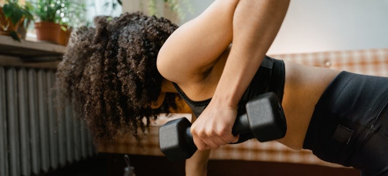 Devojka vežba kod kuće i stvara svoju rutinu što je jedan od načina šta raditi kada izgubite motivaciju za vežbanje.