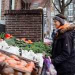 Devojka gleda zimsku hranu na pijaci.