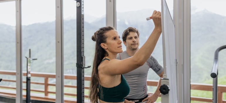Devojka beleži težinu i to je jedan od načinja praćenja napretka treninga.