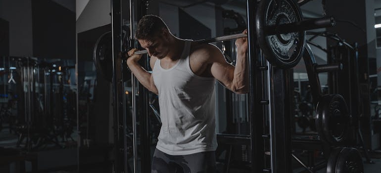 Muškarac vežba u teretani i promena ruitne vežbanja jeste jedan od načina kako prevazići stagnaciju.